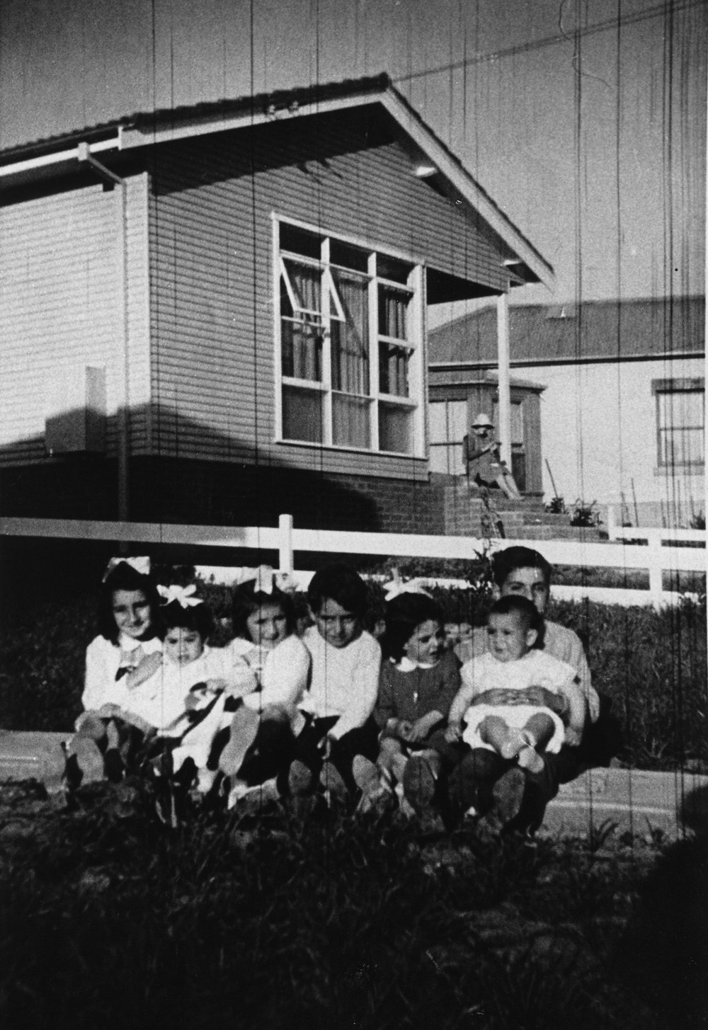 Unknown Children sitting in the front yard