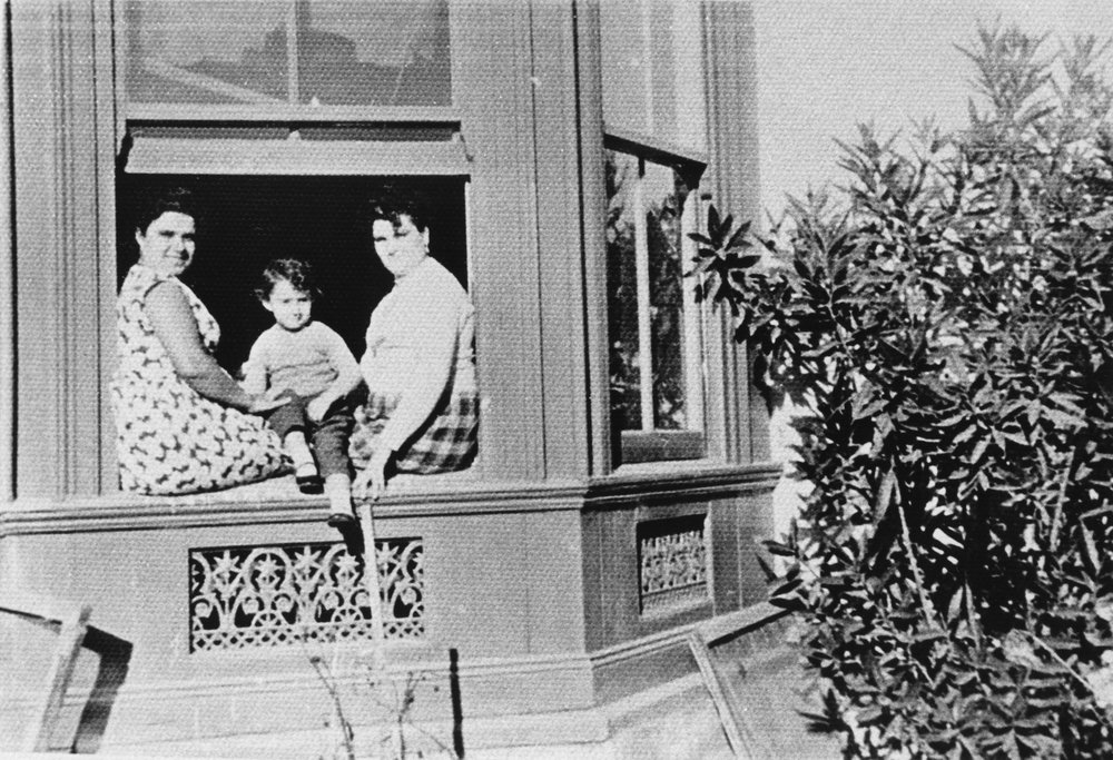 Unknown women and child sitting on a window sill