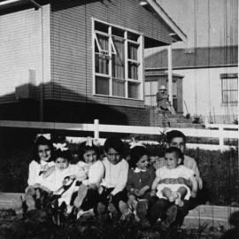 Unknown Children sitting in the front yard