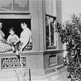 Unknown women and child sitting on a window sill